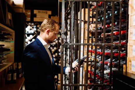 A sommellier checking a wine bottle