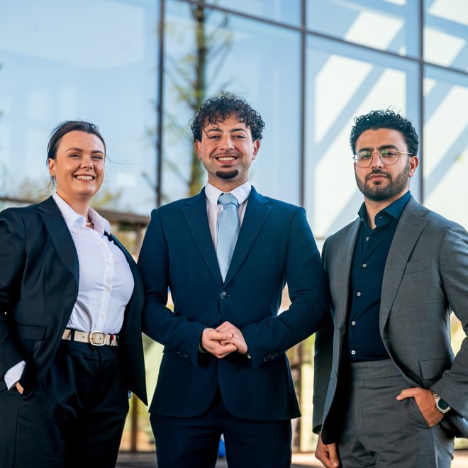 Students in suit posing in front of a building